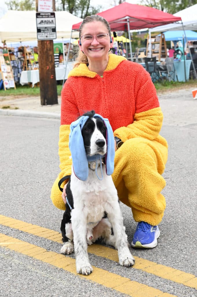 Human in Pooh costume and dog wearing Eeyore ears